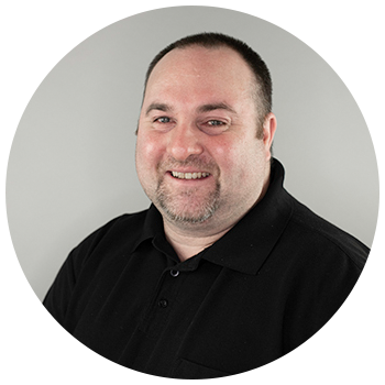 Professional headshot of man wearing dark shirt