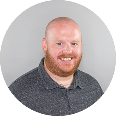 Professional headshot of man with beard smiling